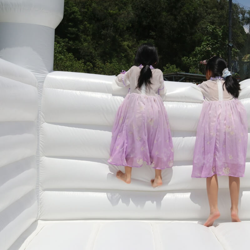 Two children standing on a bounce house |bouncinlife